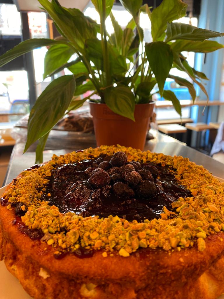 Cheesecake de pistachos y mermelada de arandanos.