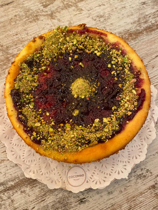 Cheesecake de pistachos y mermelada de arandanos.